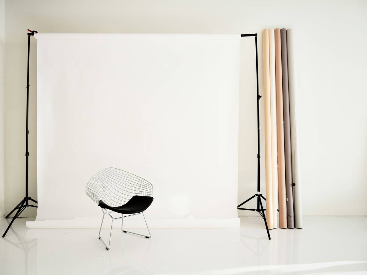 Compact travel-friendly backdrop stand assembled in a hotel room with seamless paper roll